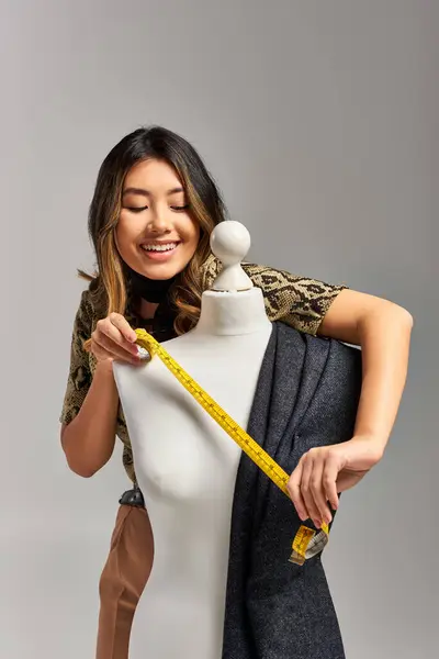 Excited Asian Clothes Stylist Holding Measuring Tape Mannequin Fabric Grey — Stock Photo, Image