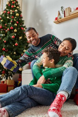 happy african american family spending time together on Christmas morning exchanging presents clipart