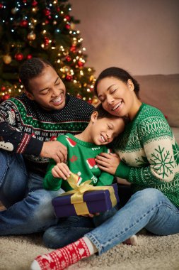 vertical shot of loving african american family hugging warmly and smiling happily, Christmas clipart