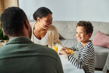 Annesi neşeyle gülümserken, Afrikalı sevimli Amerikalı çocuğun babasına bakmasına odaklan.