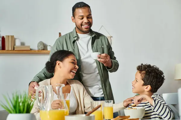 居心地の良い家庭の陽気なアフリカ系アメリカ人家族は コーヒーとオレンジジュースで朝食を食べる — ストック写真
