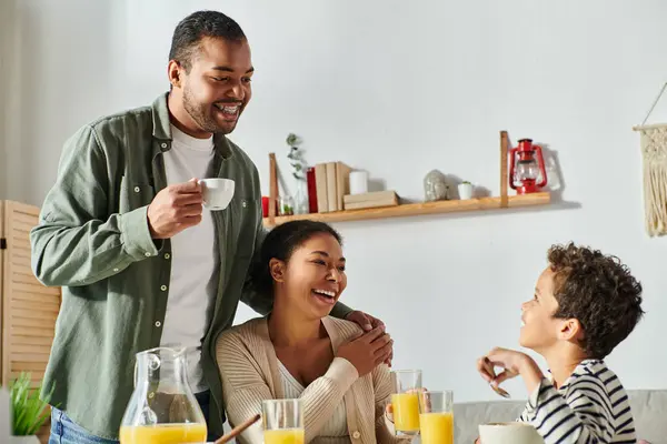 カジュアルな家庭での陽気なアフリカ系アメリカ人の家族は おいしい朝食を食べて 肩に手をつけます — ストック写真