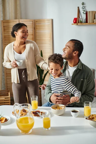 美しい喜びのアフリカ系アメリカ人の家族の垂直ショット 笑って 朝食で楽しい時間を過ごす — ストック写真