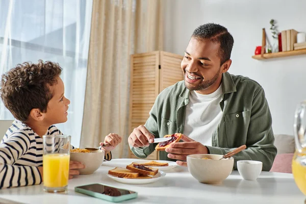 Görünümlü Afrikalı Amerikalı Baba Tostun Üzerine Reçel Sürüyor Kahvaltıda Oğluna — Stok fotoğraf