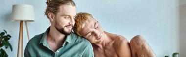 Mutlu eşcinsel adam gülümseyen sakallı erkek arkadaşına yaslanıyor modern yatak odasında oturuyor, afiş