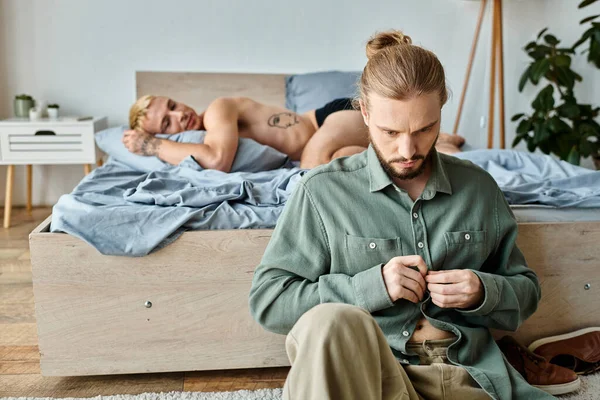 ラブパートナーの近くのベッドルームでドレスを着て怒ったゲイ男性 朝寝る 愛の問題 — ストック写真