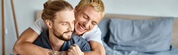 Radostný Tetovaný Gay Muž Objímající Vousatého Přítele Usmívajícího Ranní Ložnici — Stock fotografie