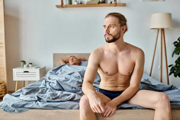 stock image upset bearded man in underpants sitting and looking away near love partner sleeping in bedroom