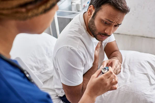 stock image cropped view of african american nurse giving inhaler to indian man having problems with breathing