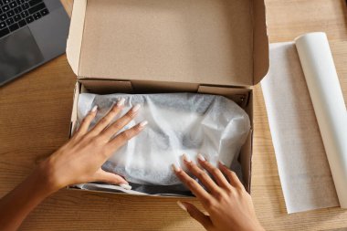 Göndermeden önce genç Afro-Amerikan kadın satıcının paketleme kutusu, teslimat konsepti