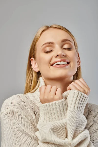 Delighted Blonde Woman Warm Knitted Sweater Smiling Closed Eyes Grey — Stock Photo, Image
