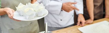 cropped view of mature chef teaching how to bake his diverse students, cooking courses, banner clipart