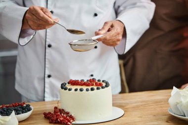 cropped view of mature male chef decorating his delicious cake professionally, cooking courses clipart