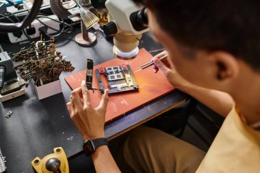 Modern tamir atölyesinde elektronik aletlerle çalışan deneyimli bir teknisyen.