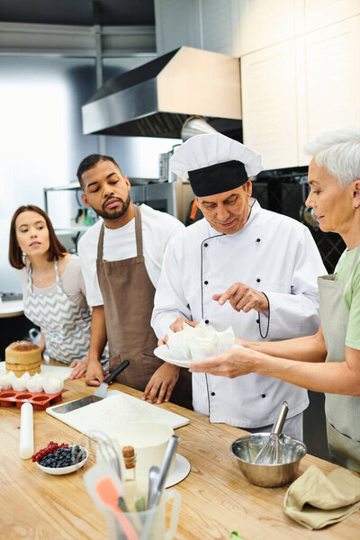 handsome concentrated chef in white hat explaining how to bake to diverse students, confectionary