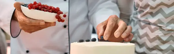 cropped view of chef decorating cake with berries next to his student, cooking courses, banner