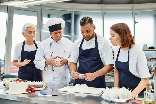 İyi görünümlü şefler, birlikte yemek yapmadan önce Afrikalı Amerikalı meslektaşlarının yumurta kırmasını izliyorlar.