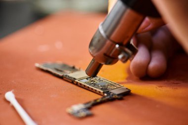 Tamir atölyesinde elektronik mikro şemayı test eden deneyimli teknisyen görüşü, küçük işletme