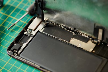 Kırık cep telefonu ve tornavida tamir atölyesinde, elektronik tamir işi konsepti