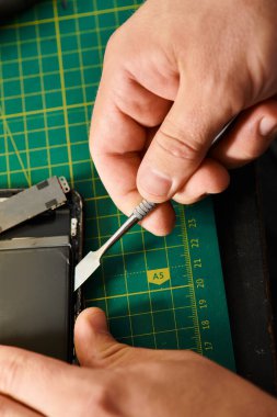Atölyede yapılan testler sırasında akıllı telefon açan yetenekli teknisyenlerin kısmi görüntüsü, küçük işletme