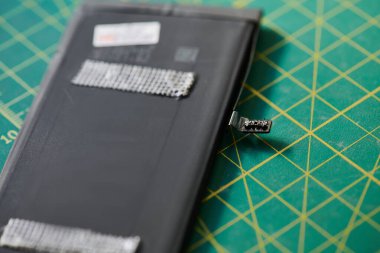 Onarım atölyesindeki cep telefonu bataryalarının ve elektronik bakım şirketlerinin görüntülerini kapat.