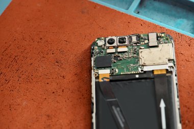 Modern atölyedeki parçalanmış cep telefonunun üst görüntüsü, ekipman onarım işi