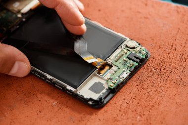 Deneyimli teknisyenlerin atölyedeki cep telefonundan bataryayı çıkarmaları, tamir işleri...
