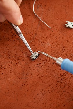 Özel atölyedeki elektronik devreyi lehimleyen profesyonel teknik uzman görüşü.
