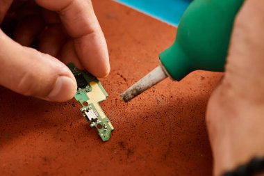 Yetenekli teknoloji uzmanının atölyedeki elektronik çip setini ve bakım işlerini temizleme görüşü