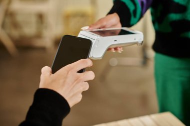 Akıllı telefon ödemesi, vejetaryen kafede akıllı telefonunu elinde tutan adamın görüntüsü.