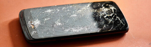 смартфон со сломанным экраном на столе в мастерской, бизнес по ремонту оборудования, горизонтальный баннер