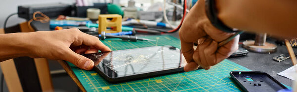 cropped view of skilled repairman removing broken touchscreen of digital tablet in workshop, banner