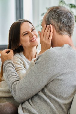 Mutlu çocuksuz çift kucaklaşıyorlar ve birbirlerine bakıyorlar evde, şefkat ve huzur içinde.