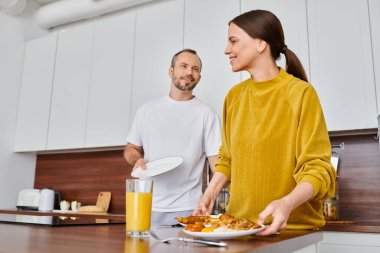Çocuksuz bir çift modern mutfakta nefis bir kahvaltı sunuyor. Huzur ve uyum.