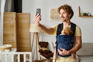 Mutlu baba, uyuyan bebekle selfie çekiyor. Taşıyıcı, babalık ve modern ebeveynlik kavramı.