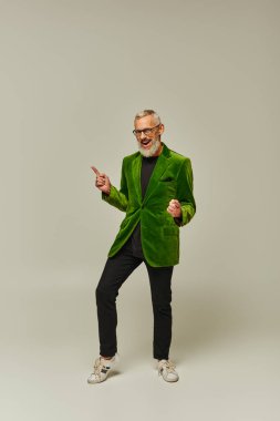 Şık giyinmiş, sakallı ve kameraya gülümseyen neşeli, yakışıklı, olgun erkek model.