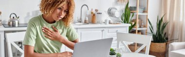 Kıvırcık Afrikalı Amerikalı kadın dizüstü bilgisayardaki video görüşmesi sırasında işaret diliyle lütfen diyor.