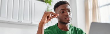 Odaklanmış Afro-Amerikalı adam evdeki bilgisayar ekranında işaret dili kullanıyor, afiş.