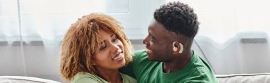 Afro-Amerikan mutlu çiftin bayrağı, işitme cihazlı sağır siyah adam ve diş teli takan kadın.
