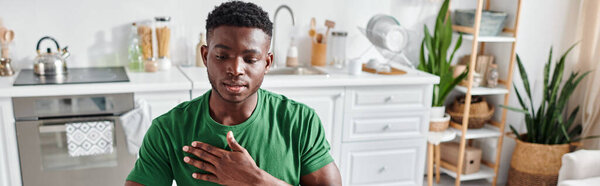 african american man in green t-shirt using sign language for online communication, banner