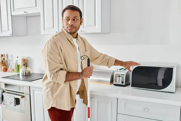 stock image good looking indian man with visual impairment wearing cozy homewear and preparing food, disabled