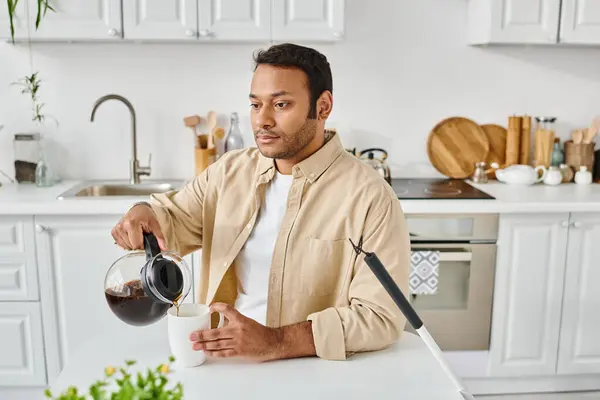 attractive indian man in casual attire with blindness sitting at table and pouring some coffee