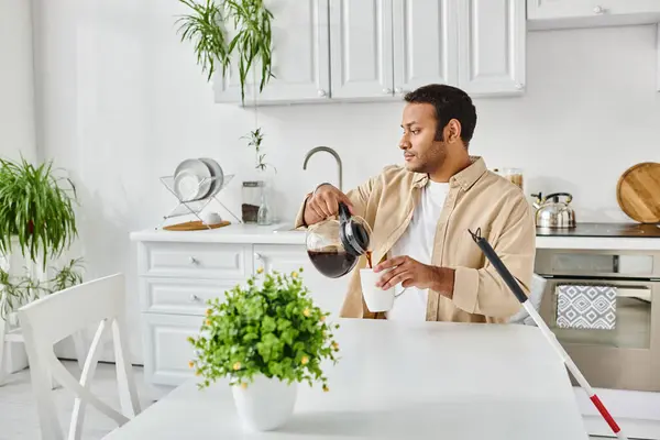 handsome indian man in casual attire with blindness sitting at table and pouring some coffee