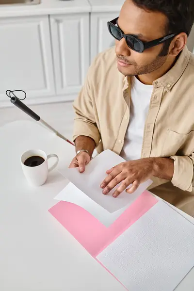 stock image handsome indian man with blindness in casual attire with walking stick reading braille code