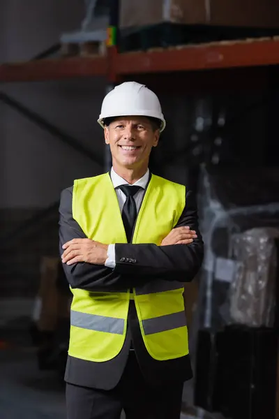 stock image Smiling man in safety vest and hard hat standing with arms crossed, professional headshot