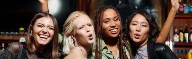 Neşeli çoklu etnik kız arkadaşlar dudaklarını büküp bardaki kameraya bakıyorlar, yatay afiş.