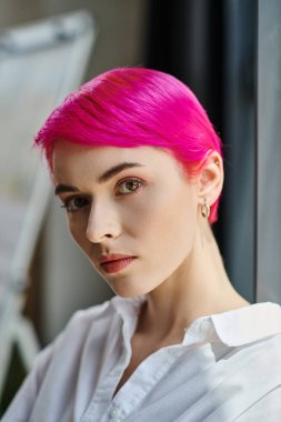 Pembe saçlı, düşünceli, çekici bir genç kadın. Poz veriyor ve kameraya bakıyor. İş konsepti.