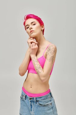 Tarz sahibi bluzlu ve mavi pantolonlu genç ve çekici bir kadın model. Yüzü ve modası birbirine yakın pozlar veriyor.