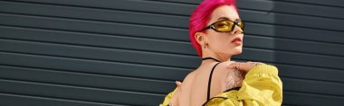 pink haired young woman in yellow sunglasses and trendy outfit posing and looking at camera, banner clipart