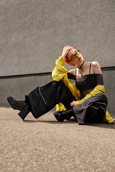 full length, pink haired woman in yellow sunglasses and trendy outfit posing and looking away